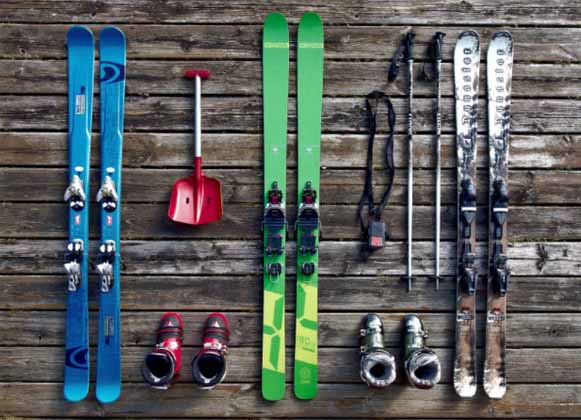 Assorted skis next to ski boots